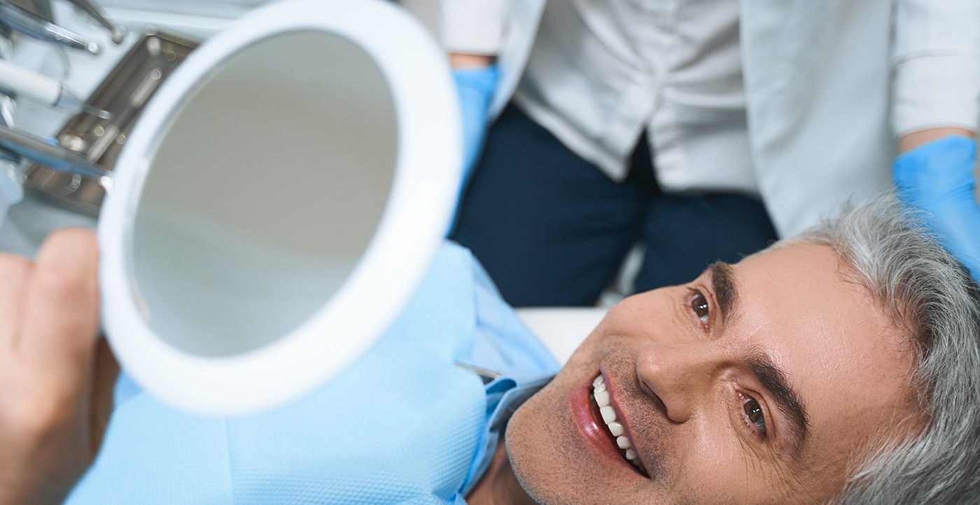 an All-on-4 patient admiring his new smile