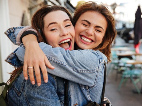 friends laughing and hugging each other