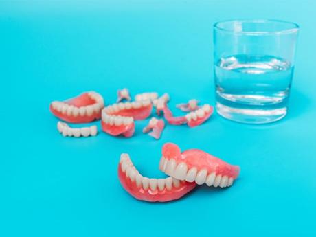 Upper and lower dentures arranged against neutral background