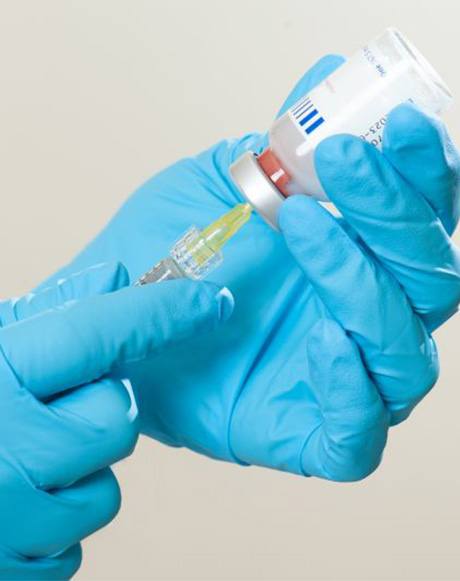 Gloved hands preparing BOTOX injection