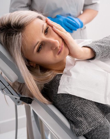 Lady with oral pain looks to dentist