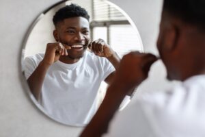 Man flossing in the mirror.